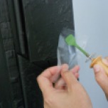 Use of a hot-tacking tool with a Teflon tip to set down the areas of lifting paint after consolidation. A barrier of silicone-release Mylar is placed between the paint layer and the heat source. Photograph by Stephanie Hornbeck.